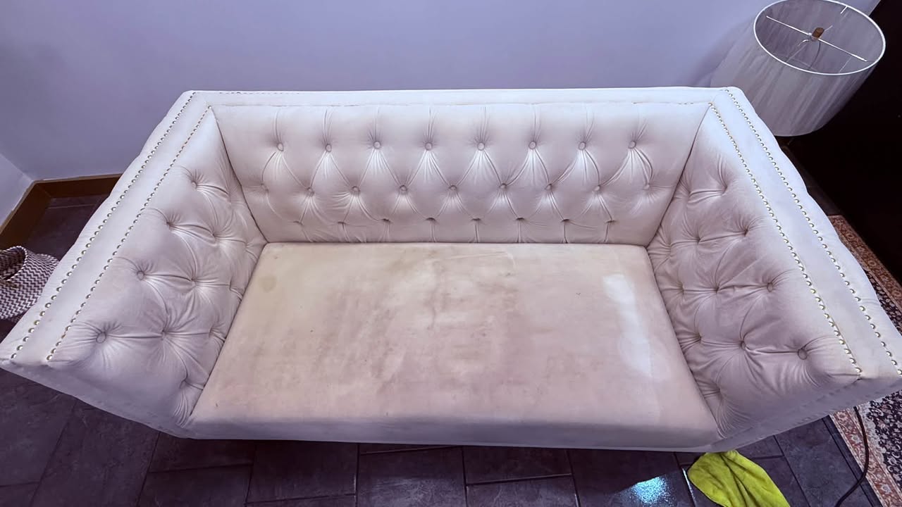 Couch cleaning before photo in Halifax — cream tufted sofa cushion with heavy pet stains